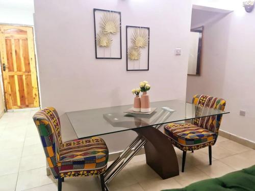 comedor con mesa de cristal y 2 sillas en Stylish 2 Bedroom House in Mtwapa, en Mtwapa