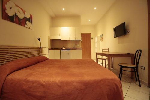 a bedroom with a bed and a kitchen with a table at Vesta-Apartments in Catania