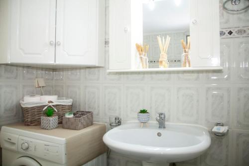 Un baño blanco con lavabo y espejo. en Olive House, en Kalamata