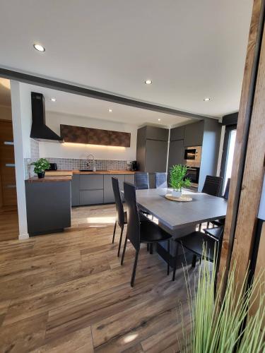 une salle à manger et une cuisine avec une table et des chaises dans l'établissement La maison des vacances 8 personnes, à Ghyvelde