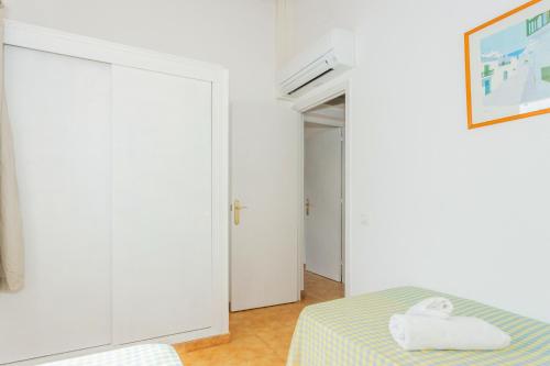 a white room with a bed with a towel on it at Son Xoriguer 14 in Son Xoriguer