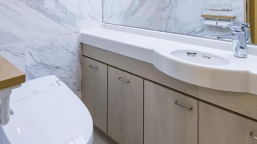 a bathroom with a white sink and a toilet at Toyoko Inn Kita-asaka-eki Nishi-guchi in Asaka