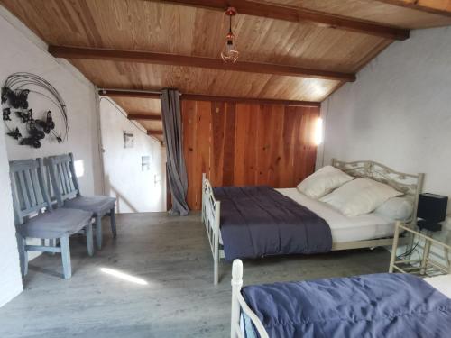 ein Schlafzimmer mit einem Bett und einer Holzdecke in der Unterkunft Maison typique oléronaise in Le Château-dʼOléron