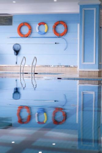 a swimming pool with orange life preservers on the wall at Sofitel Zhengzhou International in Zhengzhou