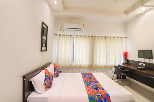 a bedroom with a bed and a desk with a computer at FabHotel Archanil Apartment - Sitanagar Cricket Ground in Nagpur