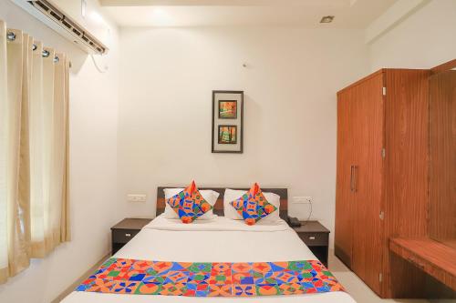 a bedroom with a bed with colorful pillows at FabHotel Archanil Apartment in Nagpur
