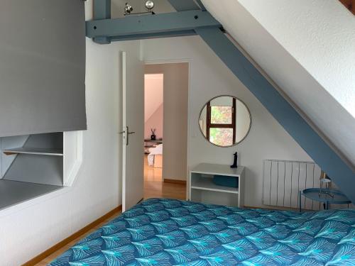 een slaapkamer met een blauw bed op een zolder bij Spacieux loft en duplex in Straatsburg