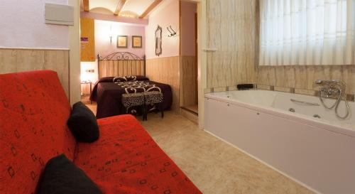 a bathroom with a red couch and a bath tub at Pension San Jose in Bullas