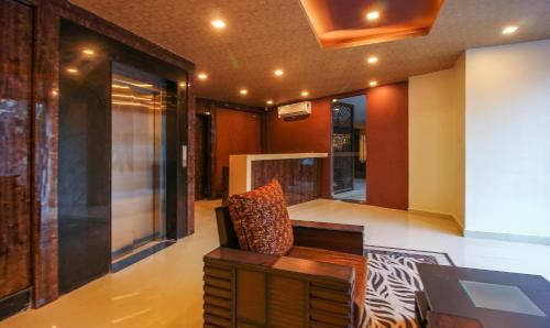 Treebo Trend Address Inn في حيدر أباد: غرفة معيشة مع أريكة وكرسي