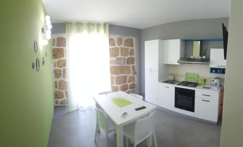 a kitchen with a white table and a white counter top at Maresol in Trappeto