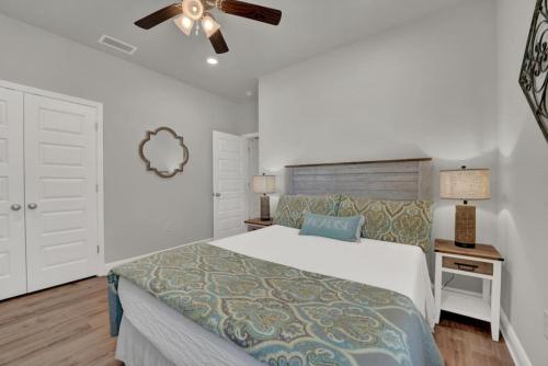 une chambre avec un lit et un ventilateur de plafond dans l'établissement Sea la Vie, à Saint Joe Beach