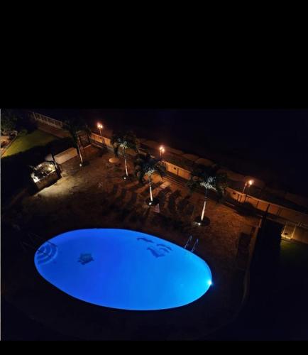 a large blue swimming pool at night with lights at Sapphire Oasis- Heavenly Ocean View and Resort in Kahana