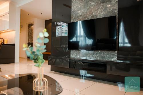 a living room with a television and a vase on a table at JOMSTAY Sunway Onsen Suites Ipoh - Lost World of Tambun Ipoh Waterpark in Tambun