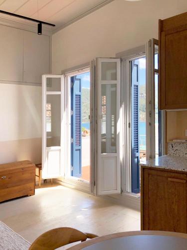 a kitchen with french doors with a view of the ocean at Giasemi house with sea view in Panormos Skopelos