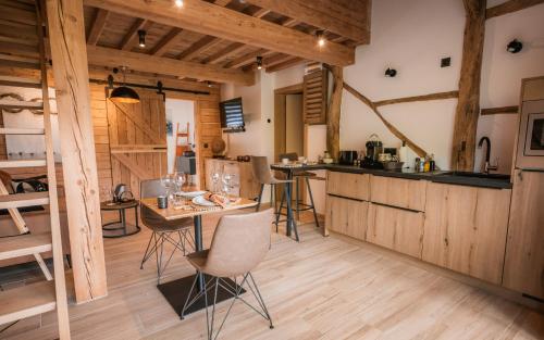 una cocina con armarios de madera, mesa y sillas en Les Monts d'Aisne en Mormont