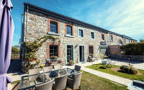 a brick building with chairs in front of it at Les Monts d'Aisne in Mormont