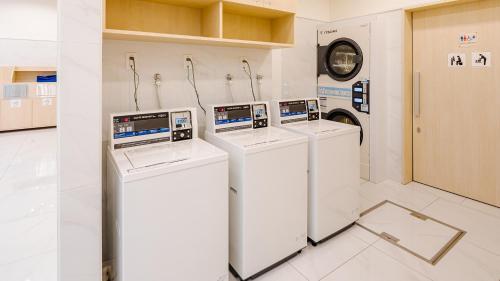 a room with three washing machines in a room at Toyoko Inn Kasukabe-eki Nishi-guchi in Kasukabe