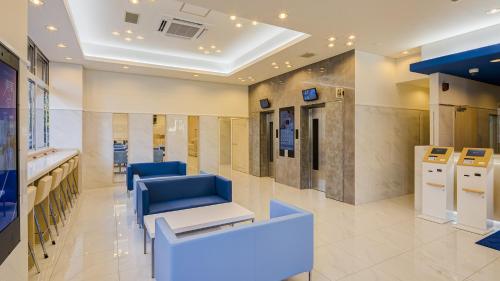 a hospital lobby with a waiting room with blue chairs at Toyoko Inn Kasukabe-eki Nishi-guchi in Kasukabe