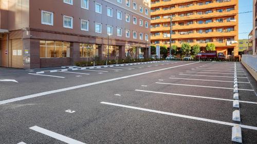 an empty parking lot in front of a building at Toyoko Inn Kasukabe-eki Nishi-guchi in Kasukabe