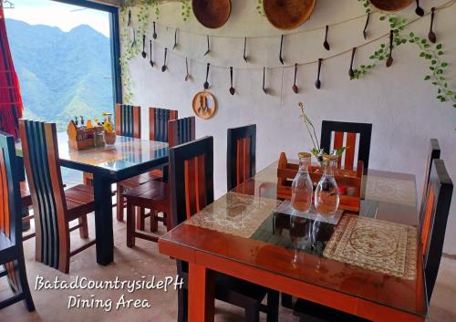 a dining room with two tables and chairs and a dining room tableablish at Batad Countryside in Banaue