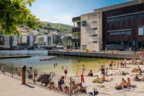 a group of people on a beach near a body of water at Håkonsgaten in Bergen