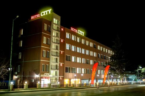 a hotel building with a sign on it at night at Hotel CITY Sandanski in Sandanski