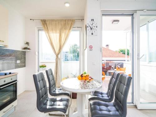 a kitchen with a white table and chairs and a window at Apartment Anka in Dubrovnik