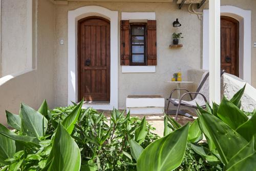 a front door of a house with green plants at Mila Malia Studios Hotel in Malia
