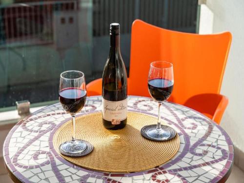 a bottle of wine and two glasses on a table at Apartment Anka in Dubrovnik