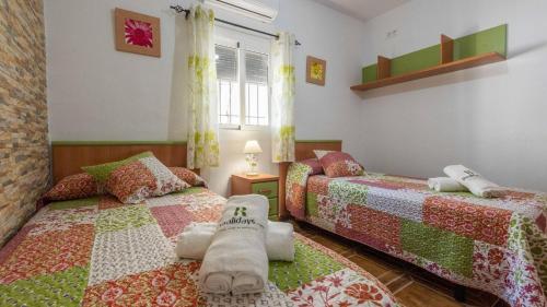 een slaapkamer met 2 bedden en een raam bij Casa Rural El Viso Rute by Ruralidays in Rute