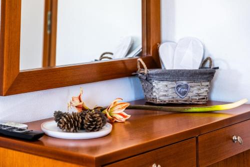 a plate of pine cones and a basket on a dresser at Anna Ageliki in Damnoni