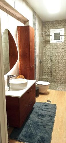 a bathroom with a sink and a toilet and a tub at Pasithea Luxury house in Archangelos