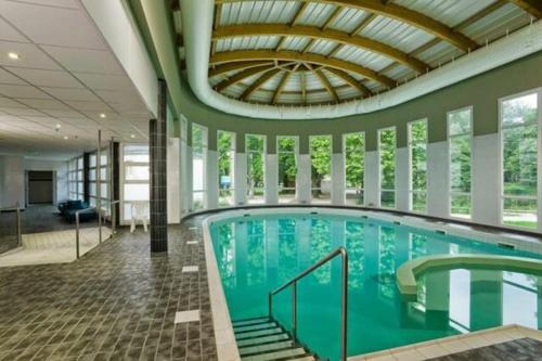 a pool in a building with a ceiling at Gîte des Anciennes Salines Nationales in Montmorot