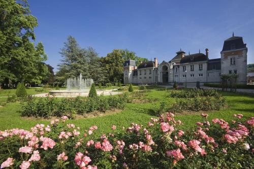 ein großes Gebäude mit rosa Blumen davor in der Unterkunft Gîte des Anciennes Salines Nationales in Montmorot