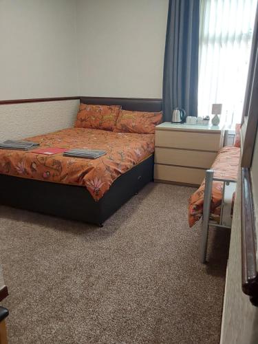 a bedroom with a bed and a table and a window at Bianca Guesthouse in Blackpool