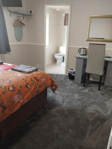 a bedroom with a bed and a desk and a bathroom at Bianca Guesthouse in Blackpool