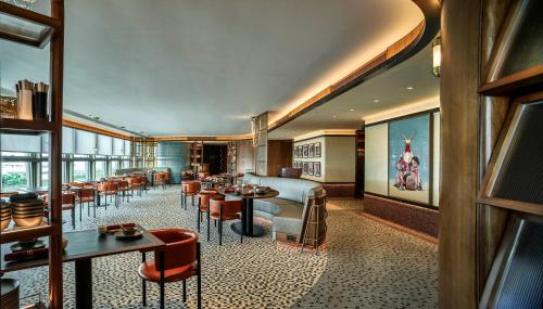 香港Oasis Aurum 181 Hotel的餐厅设有酒吧,配有桌椅