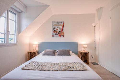 a bedroom with a large white bed with two lamps at Maison Nova - à 8 minutes de Disneyland in Magny-le-Hongre