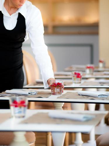 a woman standing in front of a table with glasses at San Giovanni Terme Rapolano in Rapolano Terme