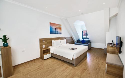 a bedroom with a bed and a couch at The Yen Residences Halong in Ha Long