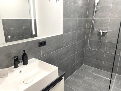 a bathroom with a white sink and a shower at Apartments Loim Lodge in Dürnstein