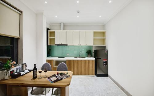 a kitchen with a wooden table and a kitchen with green at The Yen Residences Halong in Ha Long