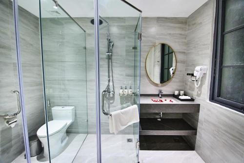 a bathroom with a shower and a toilet and a sink at The Yen Residences Halong in Ha Long