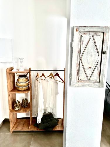 a room with a shelf with white clothes and a refrigerator at Aeron Suites in Éxo Goniá