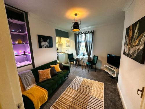 a living room with a green couch and a kitchen at Entire home/free parking /racecourse in York