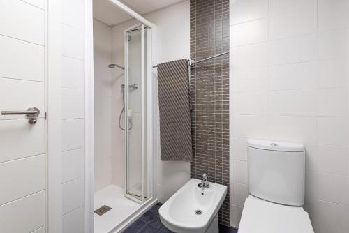 a white bathroom with a toilet and a shower at Lopimar Exclusivo in Canet de Berenguer