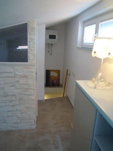 a room with a table with a lamp and a window at Brela SP small loft-no parking in Brela