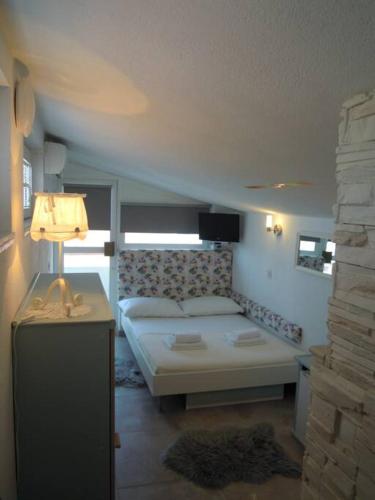 a bedroom with a bed and a lamp on a table at Brela SP small loft-no parking in Brela