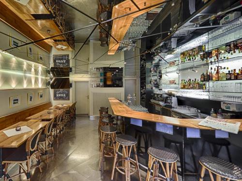a restaurant with wooden tables and bar stools at Hotel Weisses Kreuz in St. Gallen