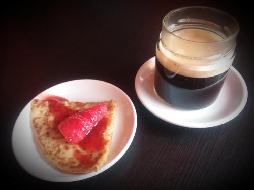 a piece of pizza on a plate next to a glass of coffee at Orange House in Varenna